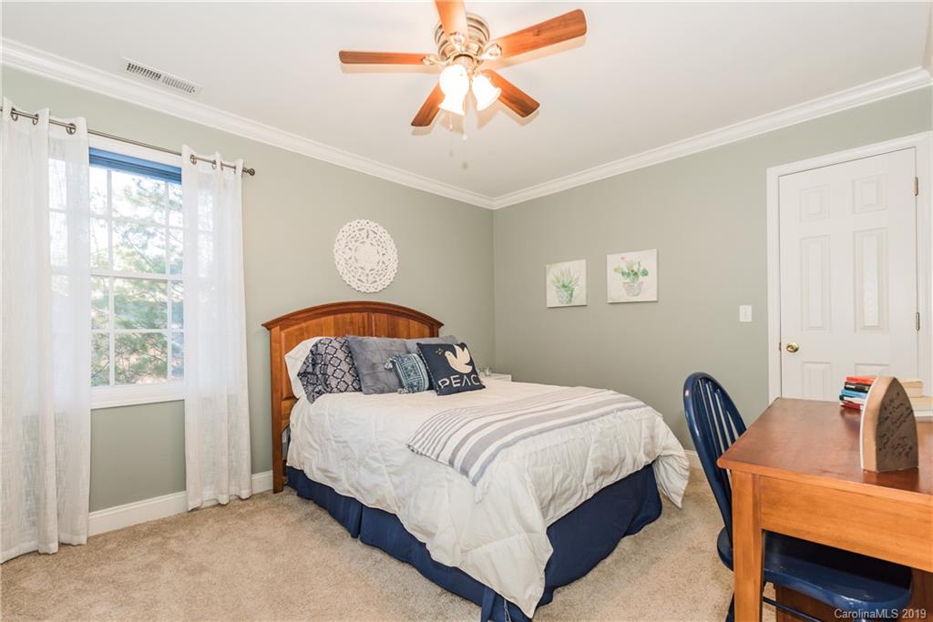 11161 Watertrace Drive Tega Cay, SC 29708 - Photo 16 of 24 a bedroom with a bed and a chandelier