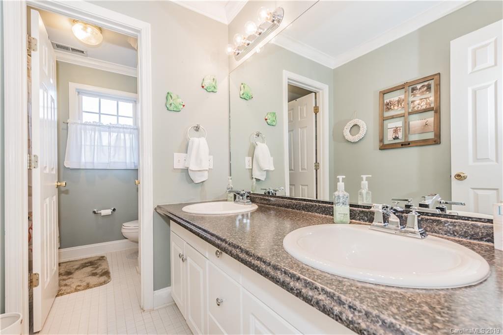 11161 Watertrace Drive Tega Cay, SC 29708 - Photo 19 of 24 a bathroom with a granite countertop double vanity sink a mirror and a