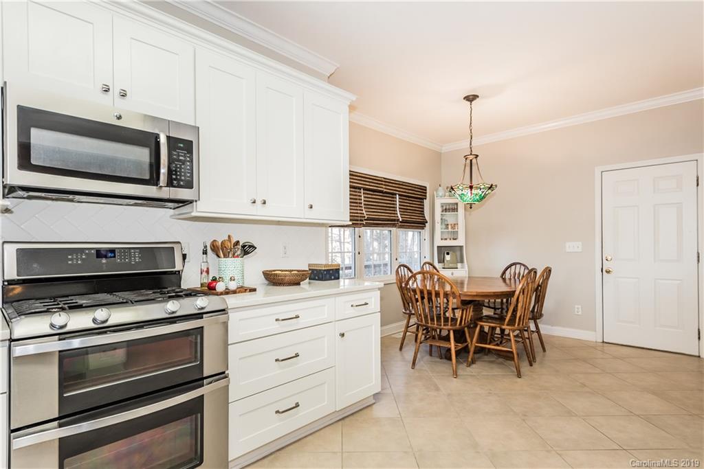 11161 Watertrace Drive Tega Cay, SC 29708 - Photo 5 of 24 a kitchen with stainless steel appliances a stove a sink island and a refrigerator