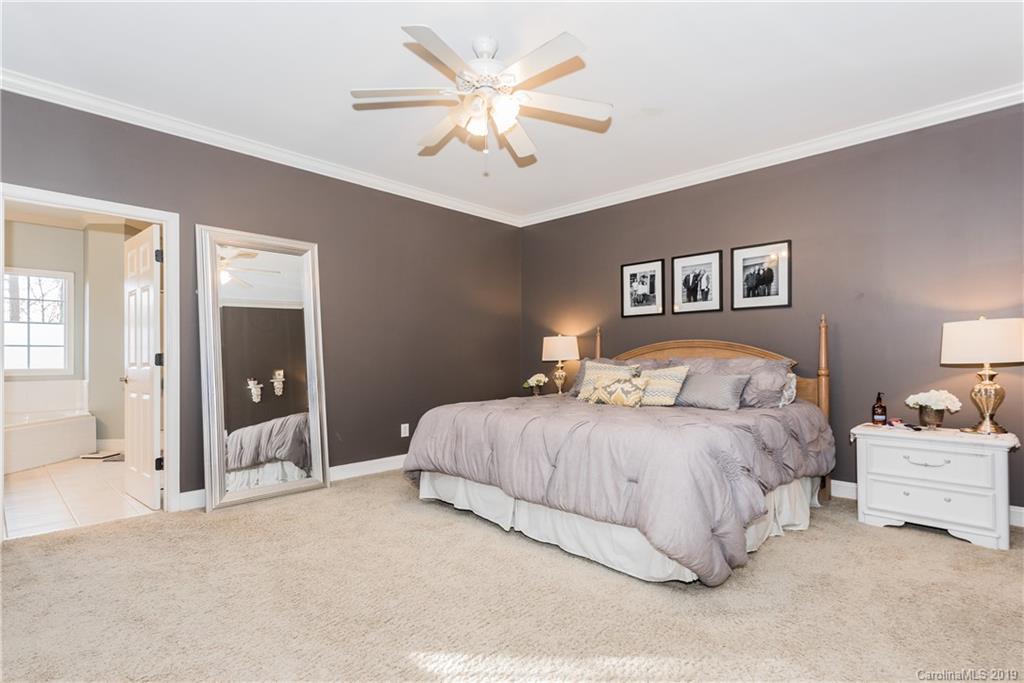 11161 Watertrace Drive Tega Cay, SC 29708 - Photo 9 of 24 a bedroom with bed and a chandelier