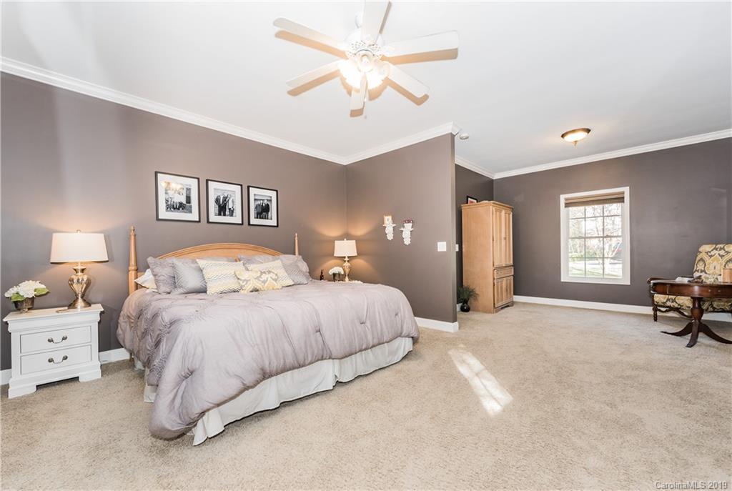 11161 Watertrace Drive Tega Cay, SC 29708 - Photo 10 of 24 a spacious bedroom with a bed and a chandelier