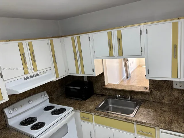 a kitchen with a sink and a stove top oven