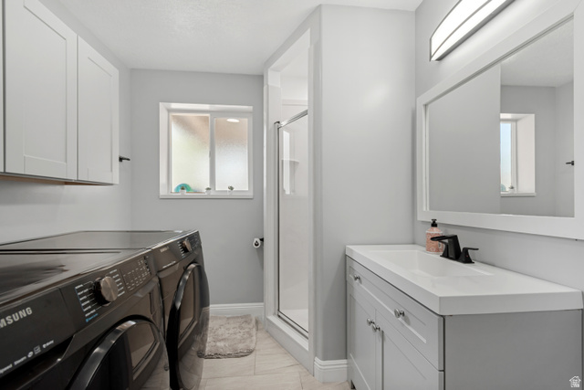 4752 South 4075th Street West Roy, UT 84067 - Photo 19 of 28 Bathroom featuring a single vanity with a white countertop, matte black faucet, and a framed mirror with integrated lighting