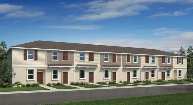 a front view of a building with lot of cars and trees