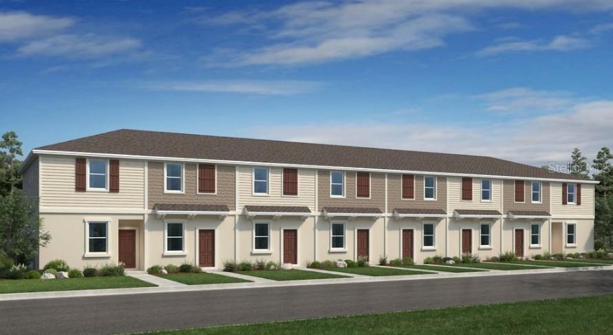 a front view of a building with lot of cars and trees