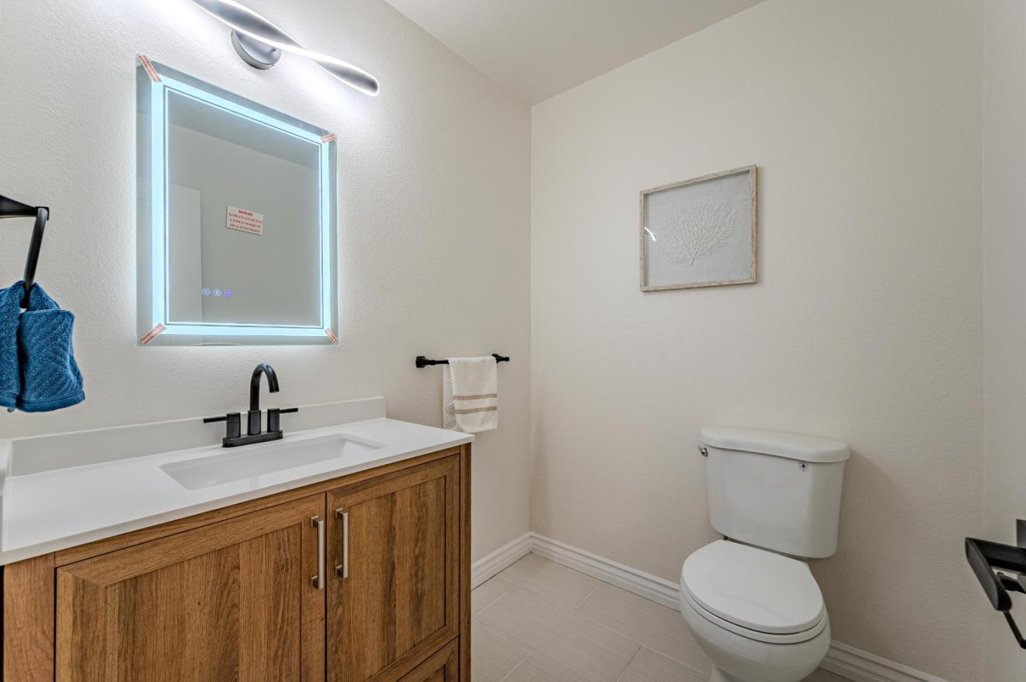 99 Jacklin Court Milpitas, CA 95035 - Photo 11 of 25 a bathroom with a toilet a sink a mirror and vanity