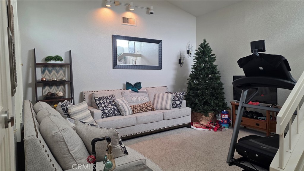 4 Leesburg Irvine, CA 92620 - Photo 5 of 18 a living room with furniture a bookshelf and a flat screen tv