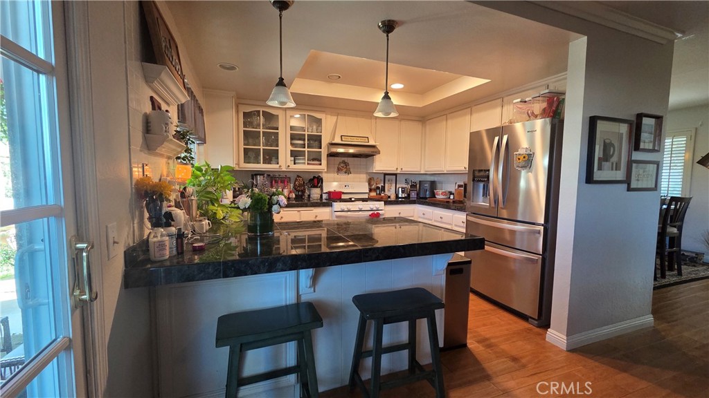 4 Leesburg Irvine, CA 92620 - Photo 7 of 18 a kitchen with stainless steel appliances granite countertop a refrigerator a sink dishwasher a stove and a dining table with wooden floor