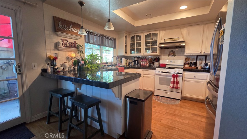 4 Leesburg Irvine, CA 92620 - Photo 8 of 18 a kitchen with stainless steel appliances kitchen island granite countertop a stove a sink and a refrigerator