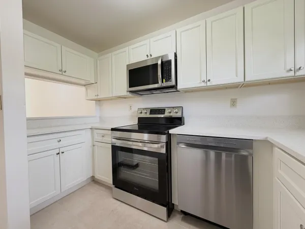 a kitchen with white cabinets and stainless steel appliances
