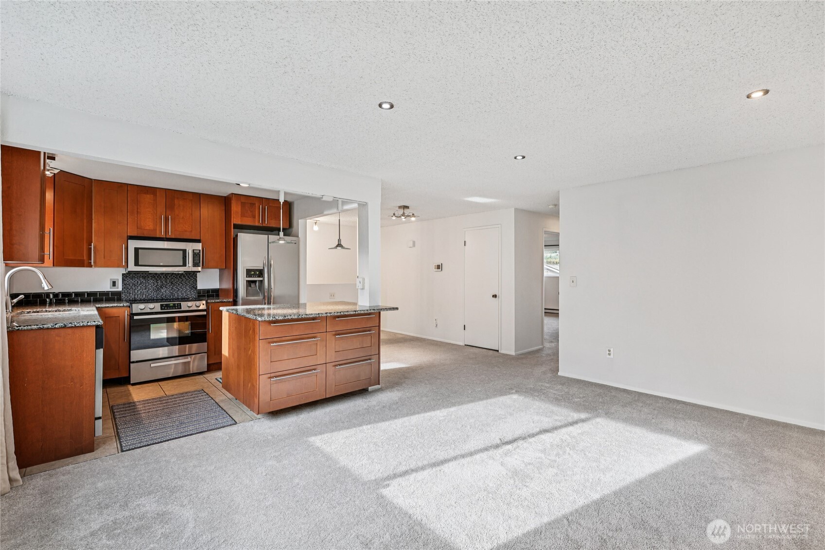 7909 218th Street Southwest, Unit 4 Edmonds, WA 98026 - Photo 10 of 29 a kitchen with stainless steel appliances wooden cabinets and granite counter tops