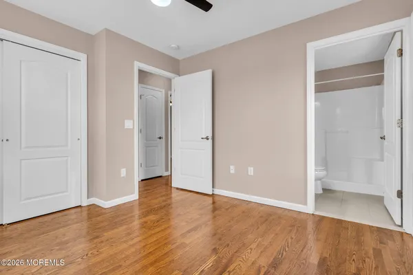 a view of an empty room with wooden floor and closet