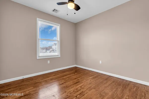 a view of empty room with wooden floor