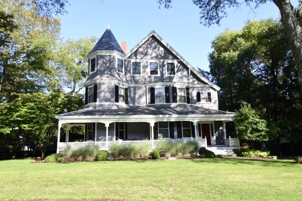 a front view of a house with a yard and potted plants
