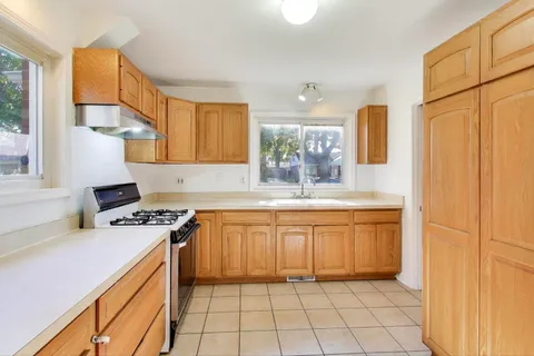 a kitchen with stainless steel appliances granite countertop a stove a sink and a refrigerator