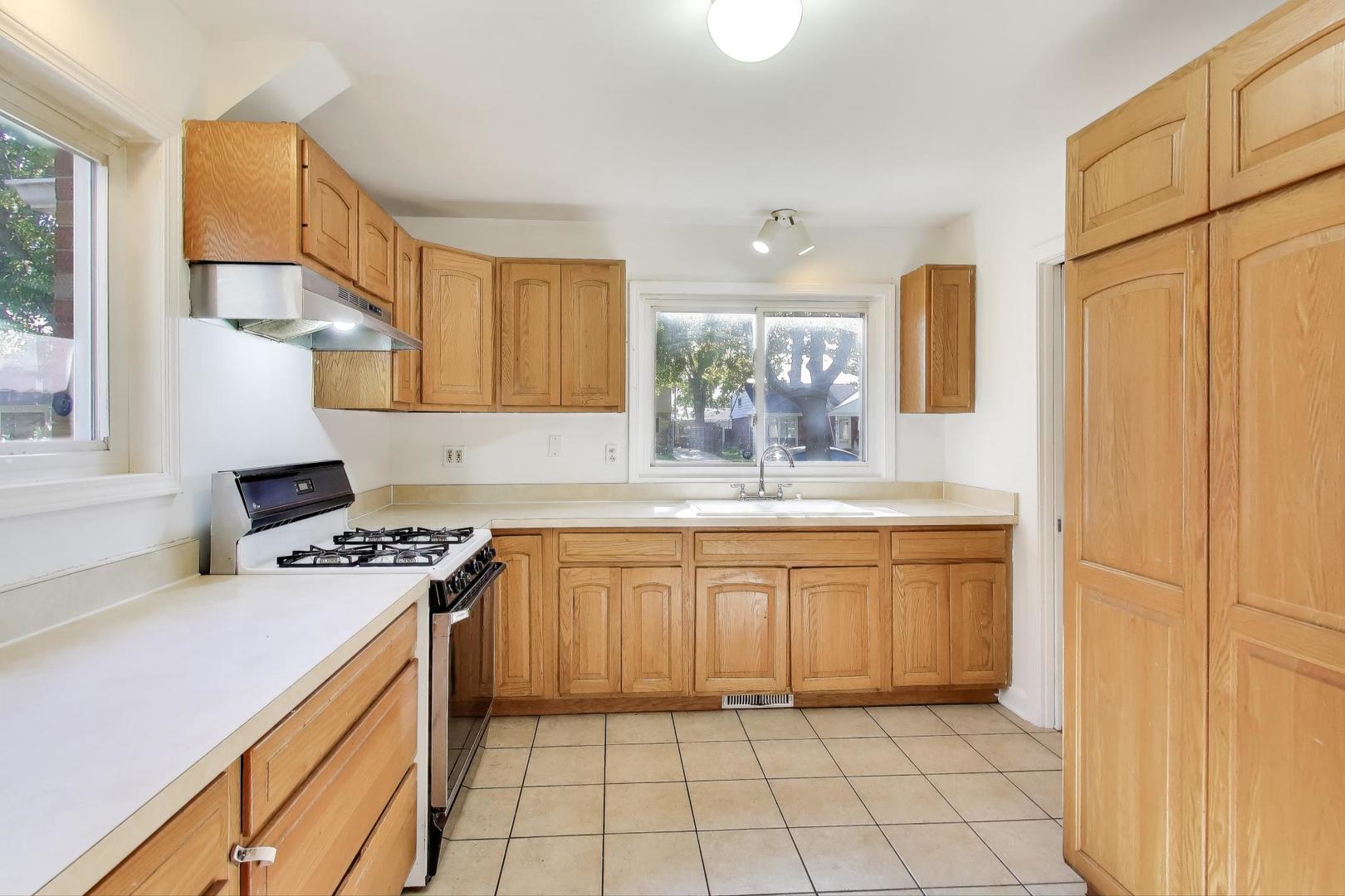 7332 Davis Street Morton Grove, IL 60053 - Photo 6 of 30 a kitchen with stainless steel appliances granite countertop a stove a sink and a refrigerator