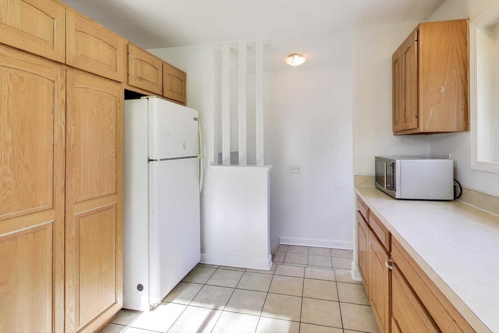 7332 Davis Street Morton Grove, IL 60053 - Photo 7 of 30 a kitchen with a refrigerator and cabinets