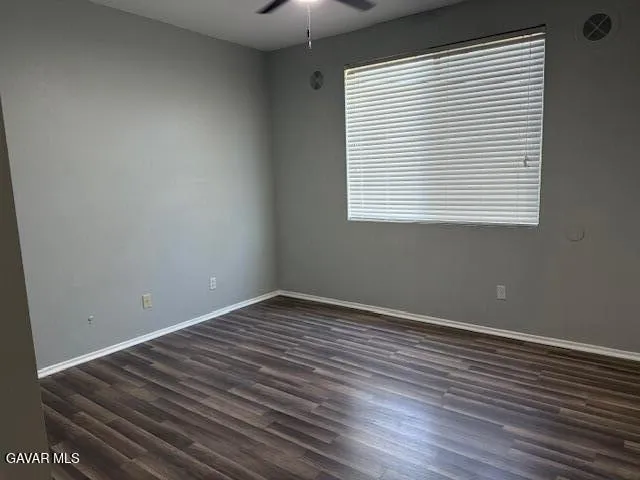 an empty room with wooden floor and a window