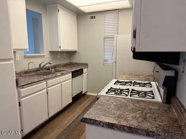a kitchen with granite countertop a sink and a stove