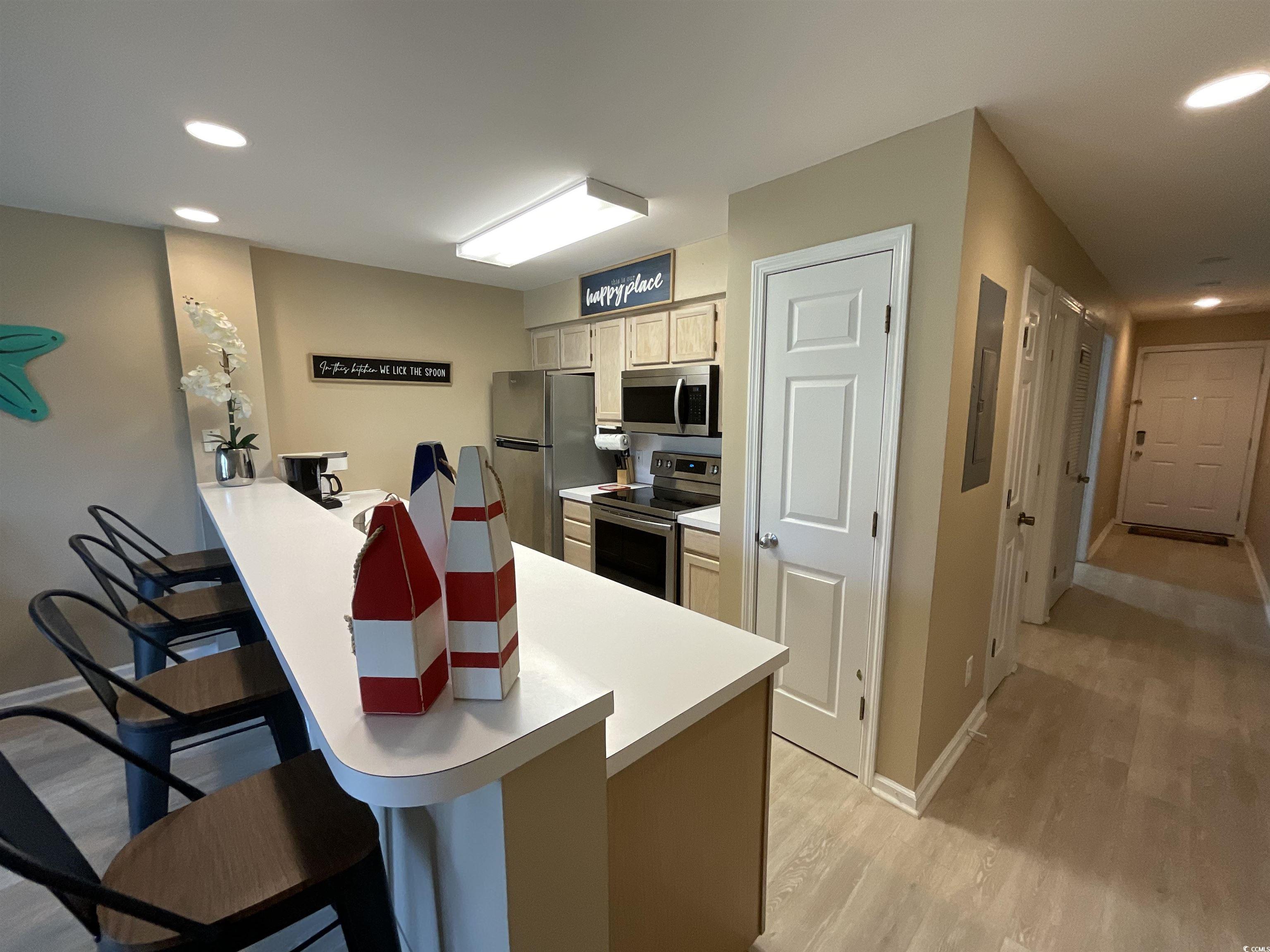 1900 Duffy Street, Unit L5 North Myrtle Beach, SC 29582 - Photo 11 of 18 Kitchen with appliances with stainless steel finishes, a breakfast bar, light wood-style flooring, baseboards, and recessed lighting