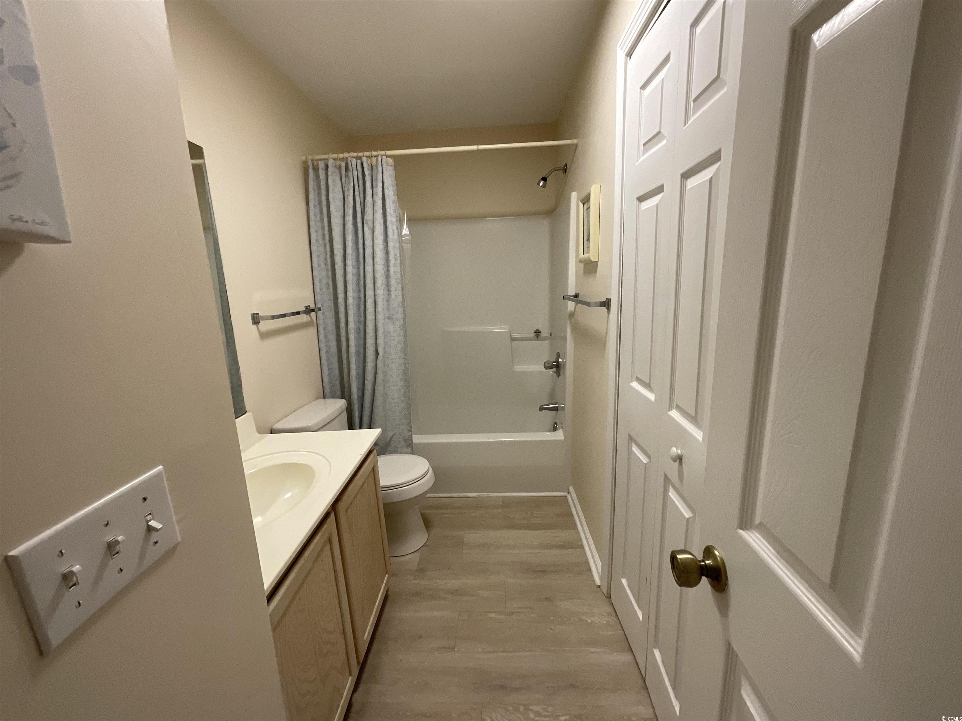 1900 Duffy Street, Unit L5 North Myrtle Beach, SC 29582 - Photo 5 of 18 Bathroom with toilet, vanity, wood finished floors, and shower / bath combo
