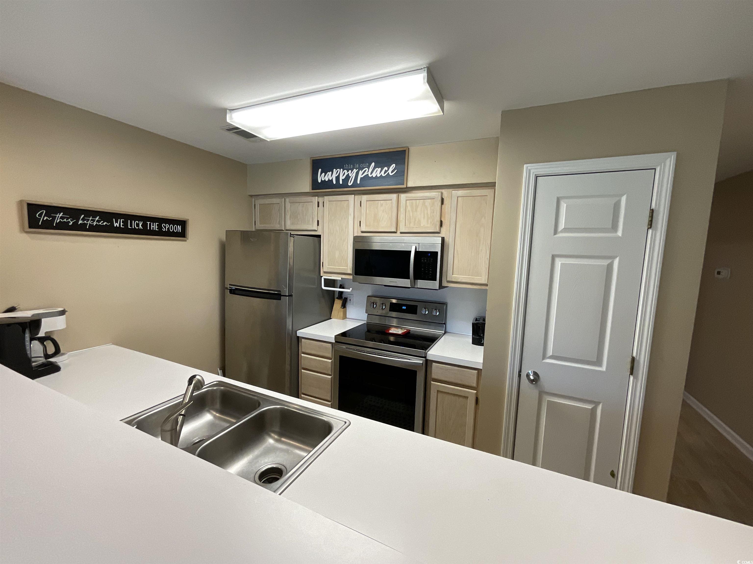 1900 Duffy Street, Unit L5 North Myrtle Beach, SC 29582 - Photo 10 of 18 Kitchen with appliances with stainless steel finishes, light countertops, a sink, and wood finished floors