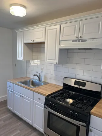 a kitchen with granite countertop white cabinets and appliances