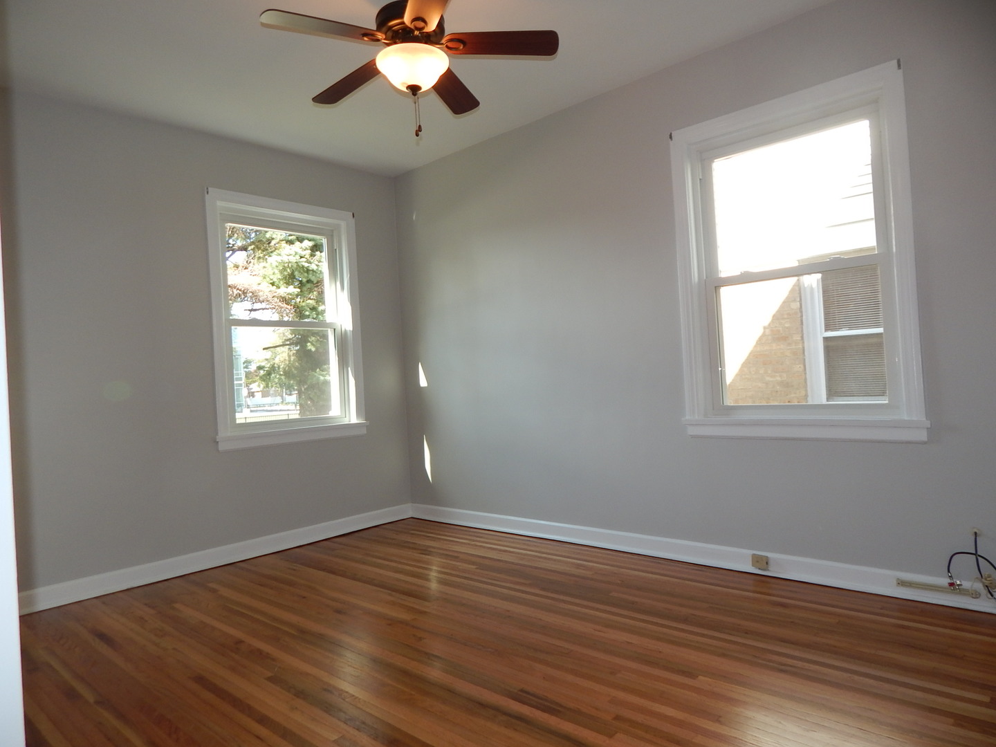 7611 East Prairie Road Skokie, IL 60076 - Photo 3 of 20 a view of an empty room with wooden floor and a window