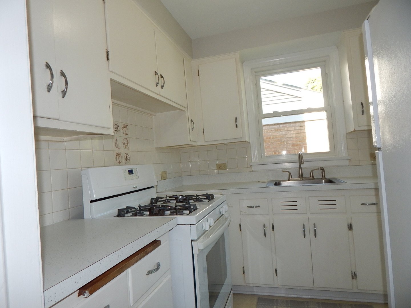 7611 East Prairie Road Skokie, IL 60076 - Photo 5 of 20 a kitchen with a sink stove and cabinets