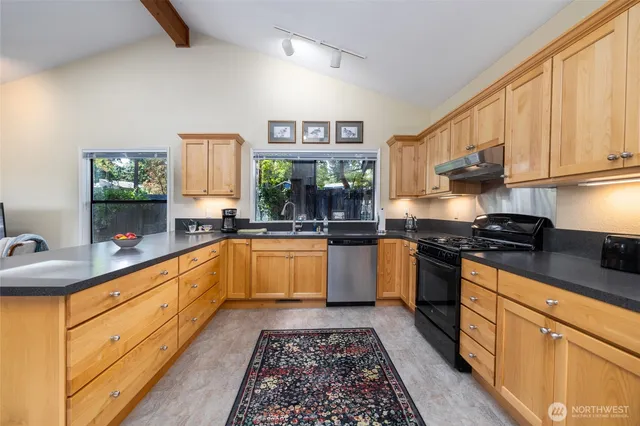 a kitchen with granite countertop a refrigerator stove top oven and sink