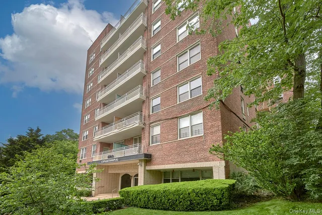 a front view of a multi story building with yard