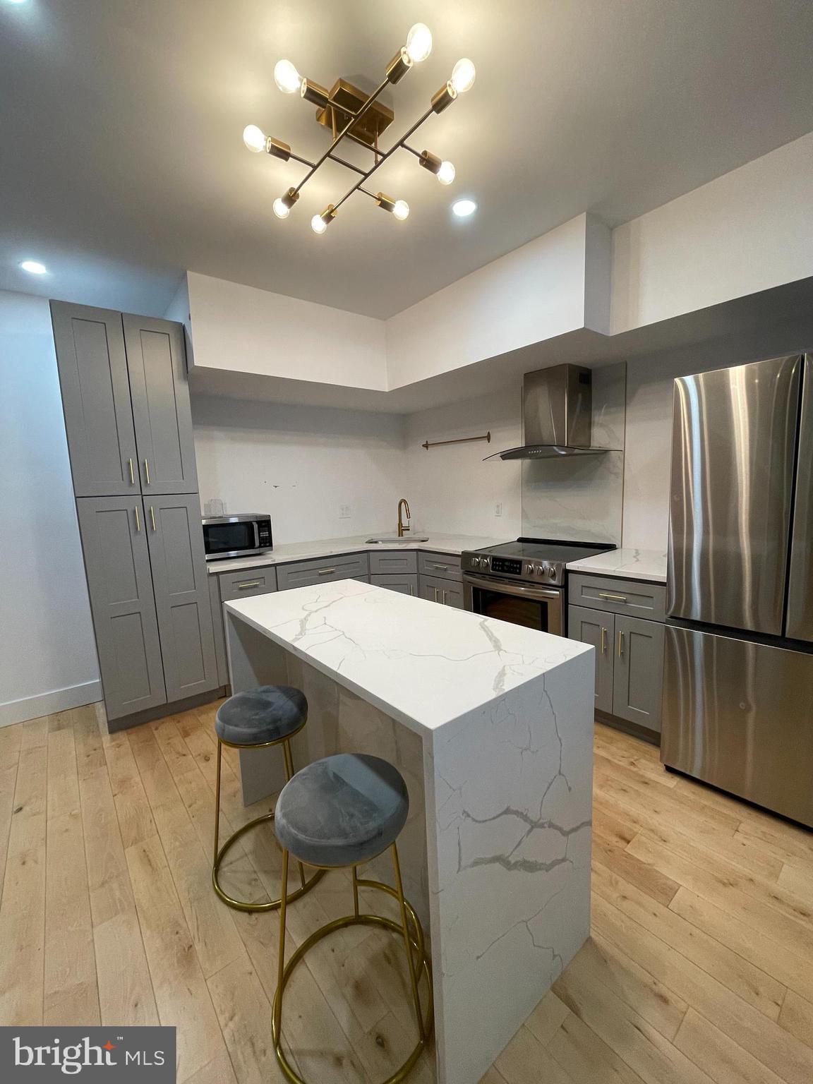 1205 South 4th Street, Unit 2 Philadelphia, PA 19147 - Photo 4 of 12 a kitchen with stainless steel appliances a table and chairs