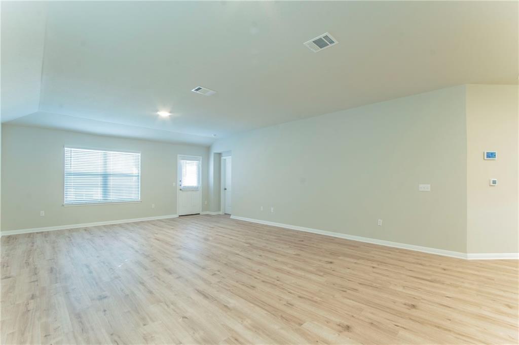 172 Arrowhead Vine Street Leander, TX 78641 - Photo 4 of 21 an empty room with wooden floor and windows