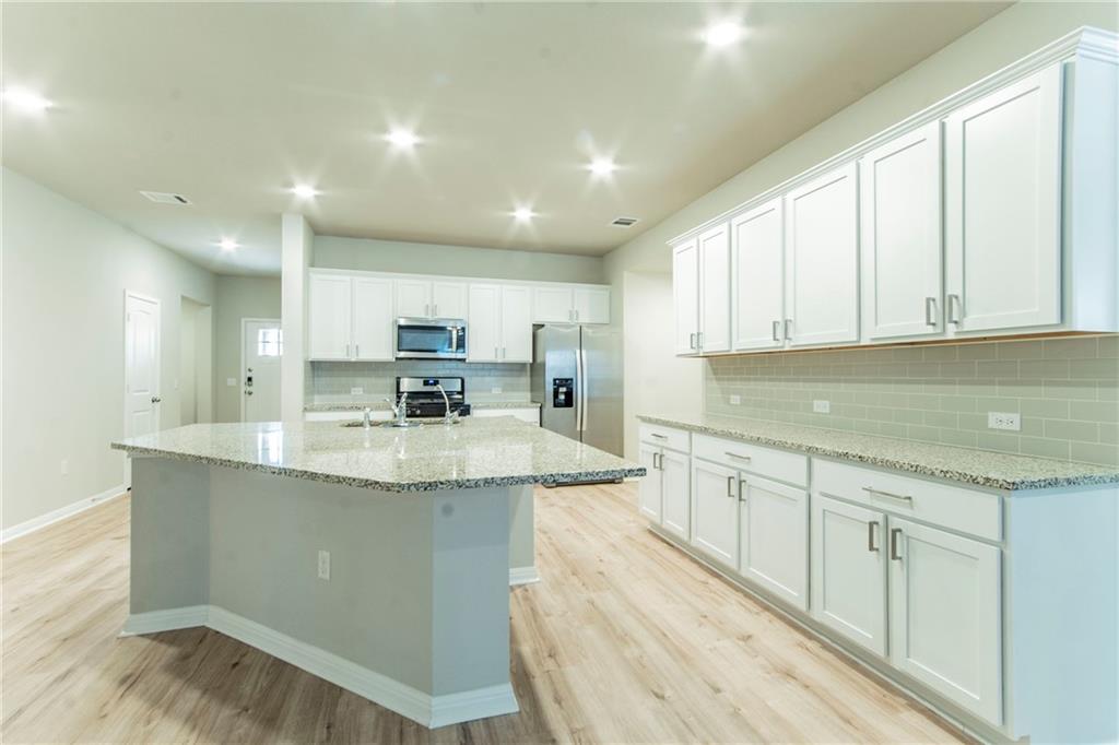 172 Arrowhead Vine Street Leander, TX 78641 - Photo 7 of 21 a kitchen with stainless steel appliances granite countertop a sink stove and cabinets