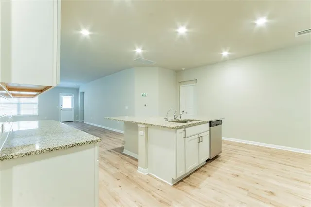 a spacious bathroom with a granite countertop sink and a mirror