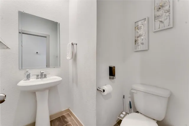 a bathroom with a toilet sink and mirror