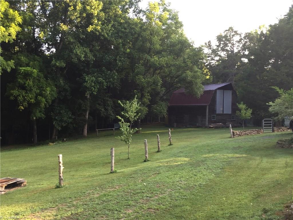 371 Foulks Road Madison, NC 27025 - Photo 29 of 30 Cleared land around the home and barn provides opportunity for keeping animals or gardening.
