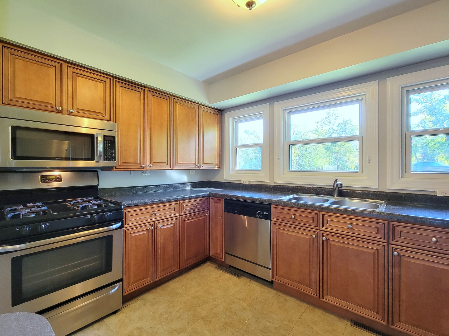 28W450 Roosevelt Road Winfield, IL 60190 - Photo 7 of 28 a kitchen with granite countertop stainless steel appliances a stove sink and microwave