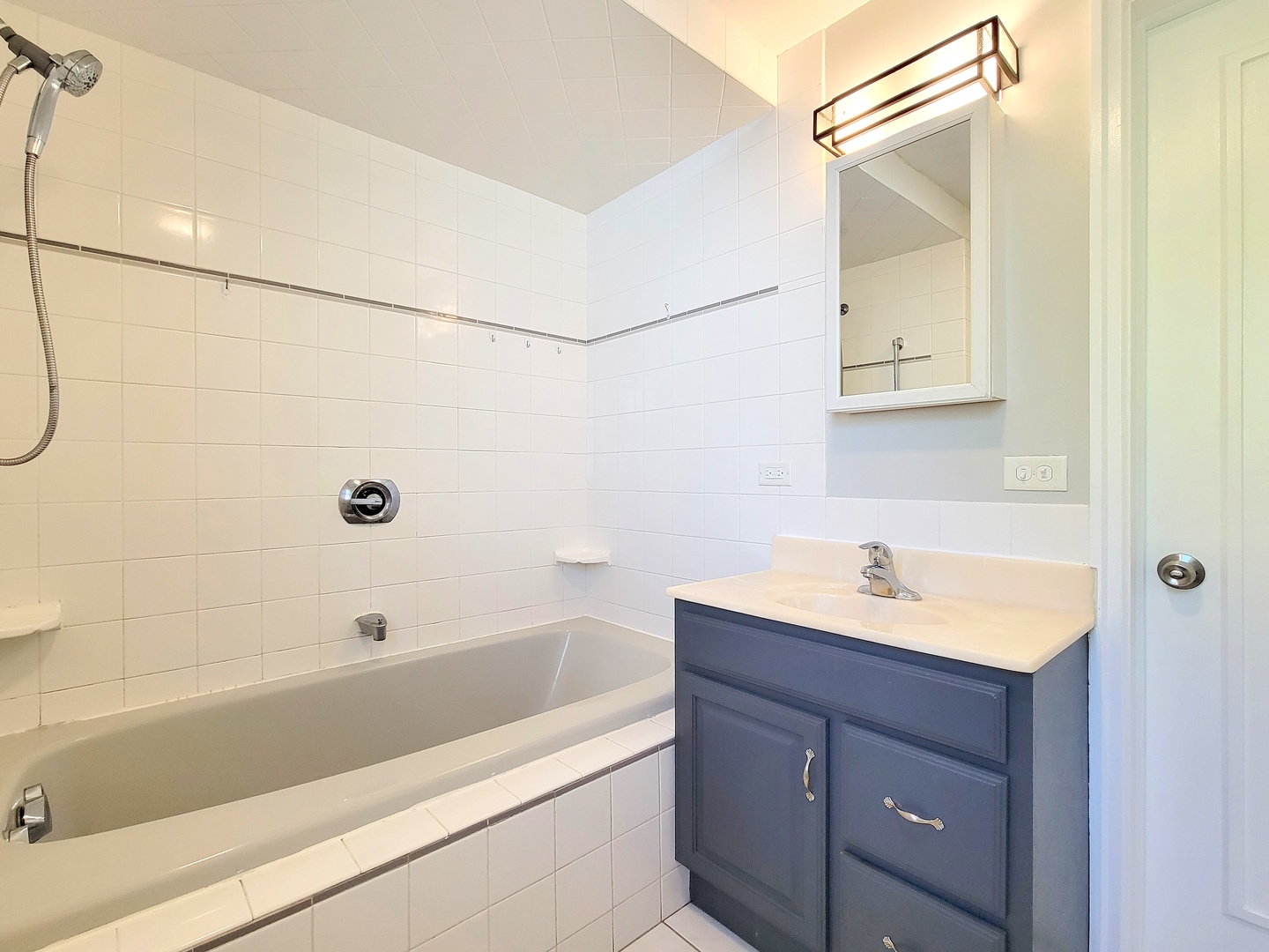 28W450 Roosevelt Road Winfield, IL 60190 - Photo 9 of 28 a bathroom with a tub sink vanity and mirror