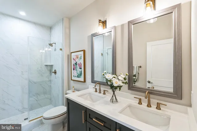 a bathroom with a sink toilet double vanity and shower
