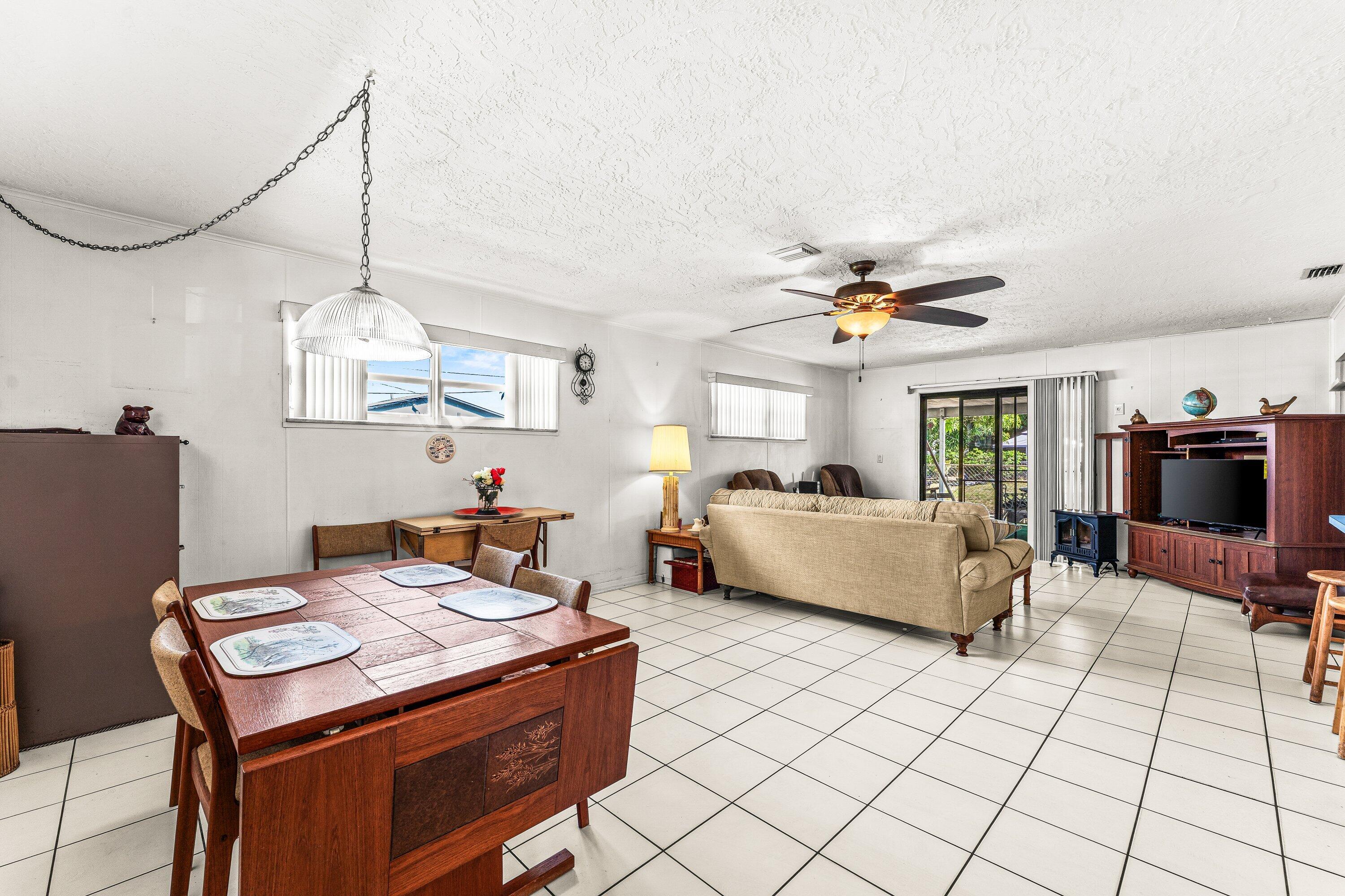 1040 West 1st Street Riviera Beach, FL 33404 - Photo 11 of 26 a living room with a table chairs and a dining table