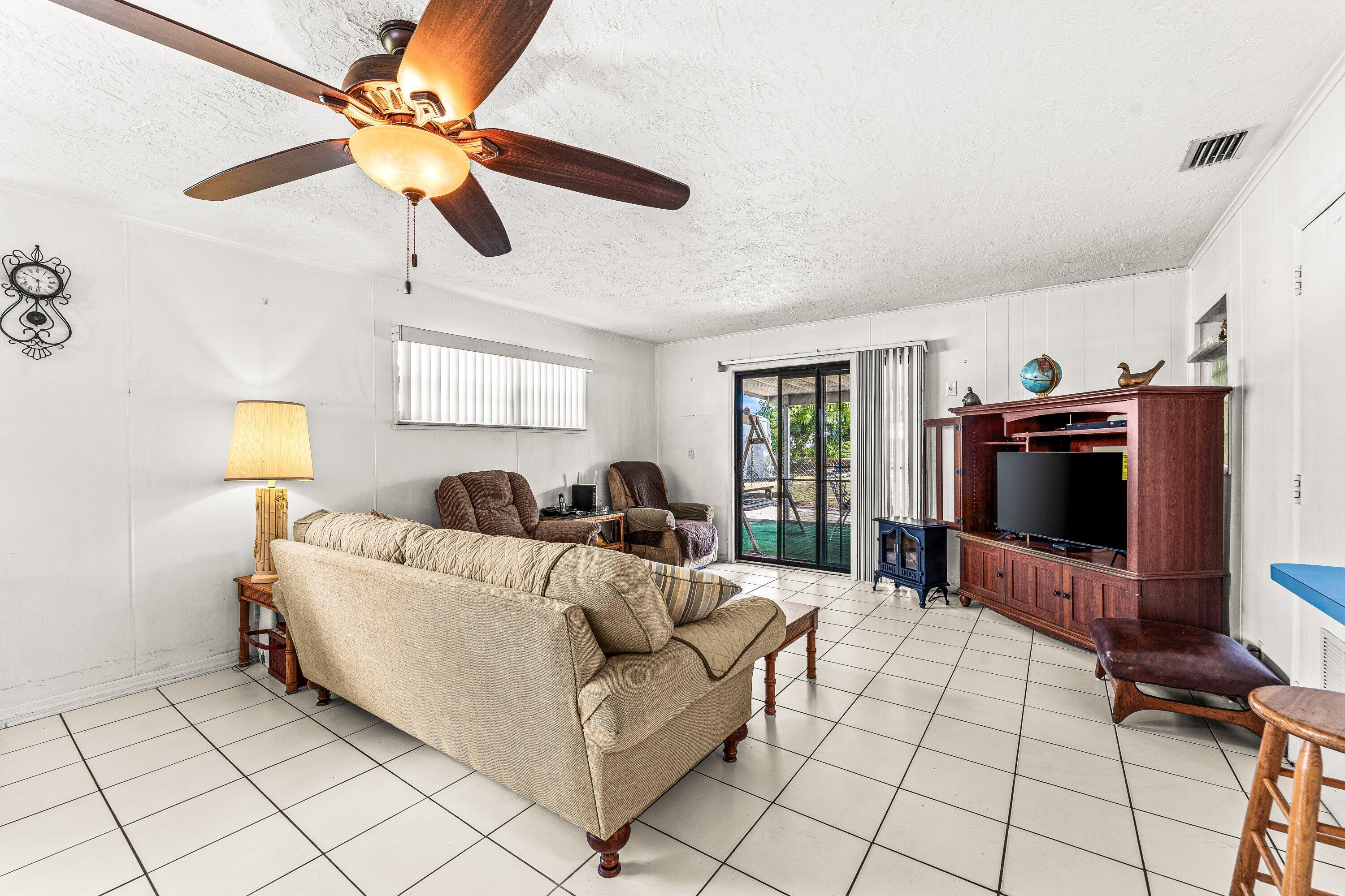 1040 West 1st Street Riviera Beach, FL 33404 - Photo 12 of 26 a living room with furniture and a flat screen tv