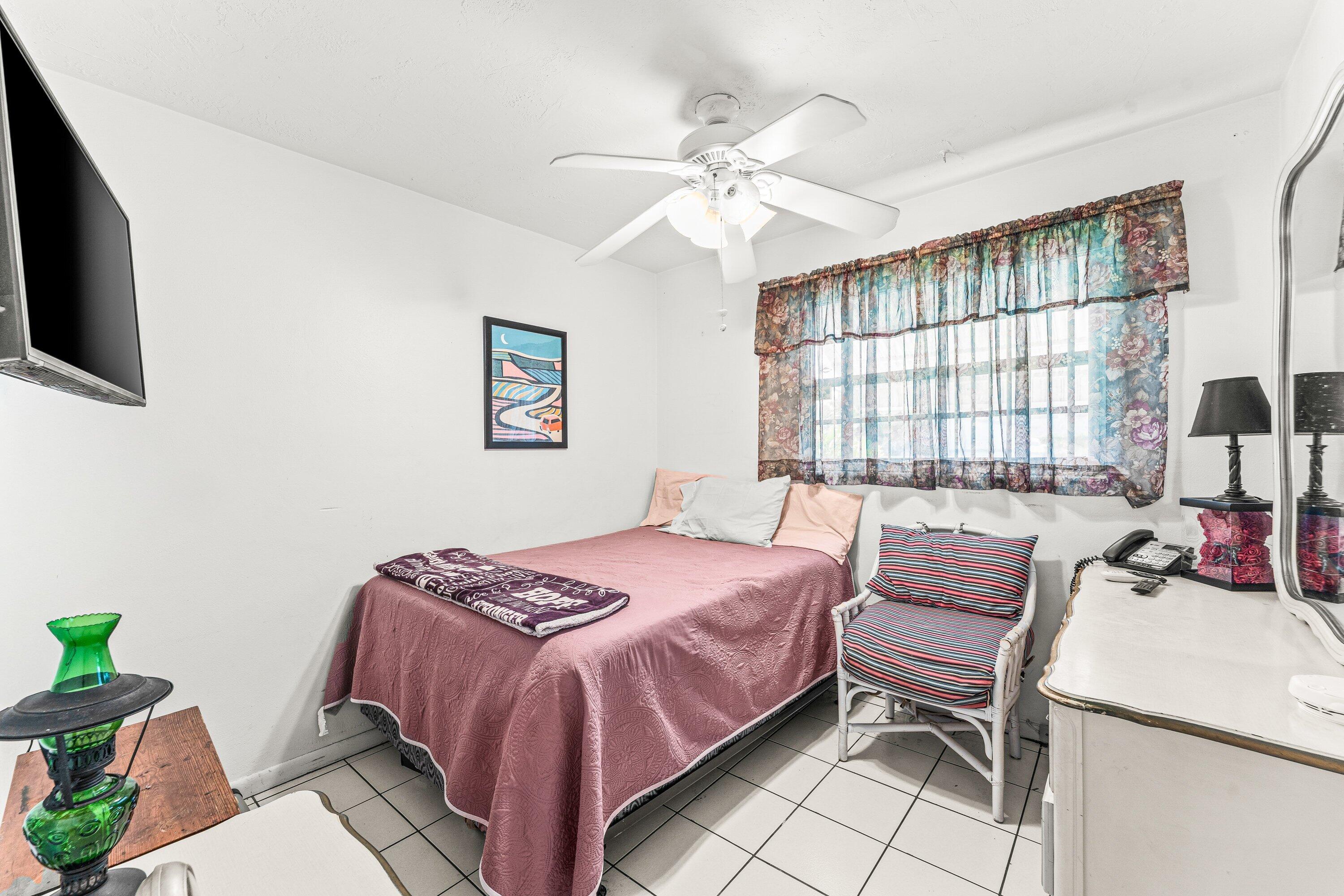 1040 West 1st Street Riviera Beach, FL 33404 - Photo 16 of 26 a bedroom with a bed and a chandelier