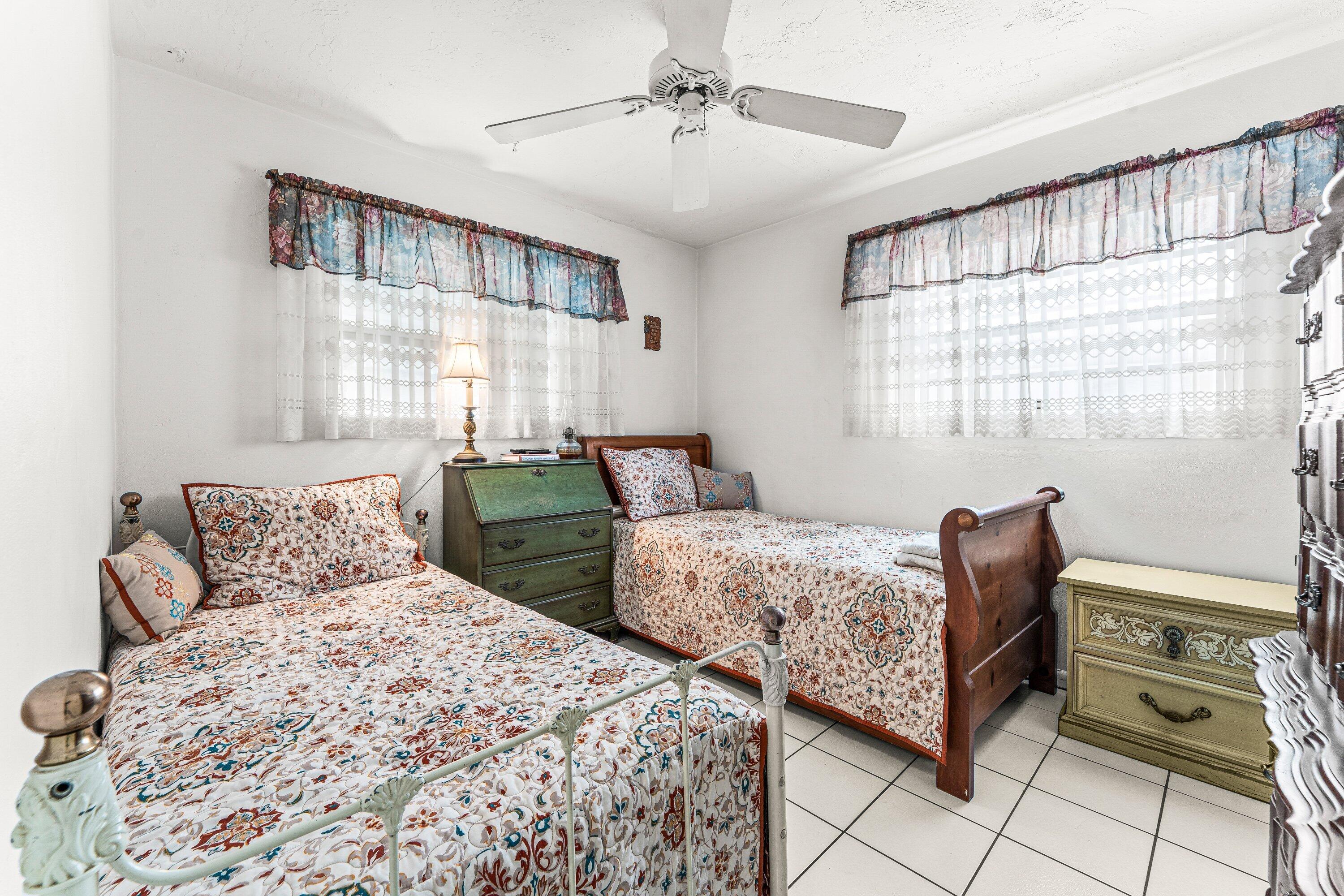 1040 West 1st Street Riviera Beach, FL 33404 - Photo 19 of 26 a bedroom with two beds and a chandelier