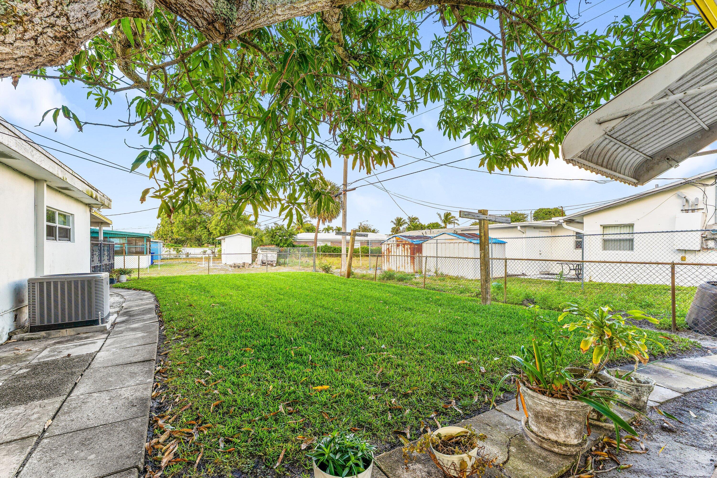 1040 West 1st Street Riviera Beach, FL 33404 - Photo 23 of 26 a view of a backyard with a garden and outdoor seating