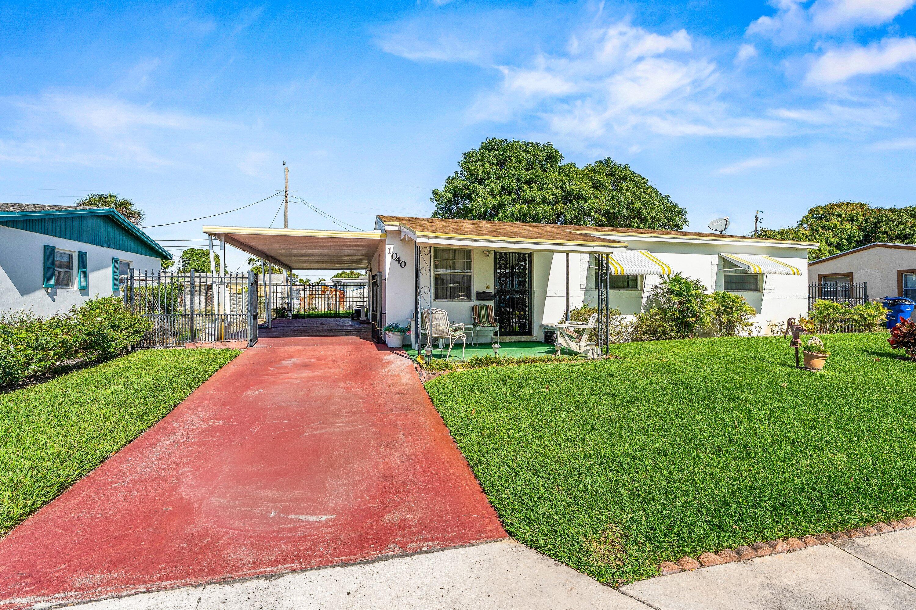 1040 West 1st Street Riviera Beach, FL 33404 - Photo 3 of 26 a front view of a house with a yard table and chairs