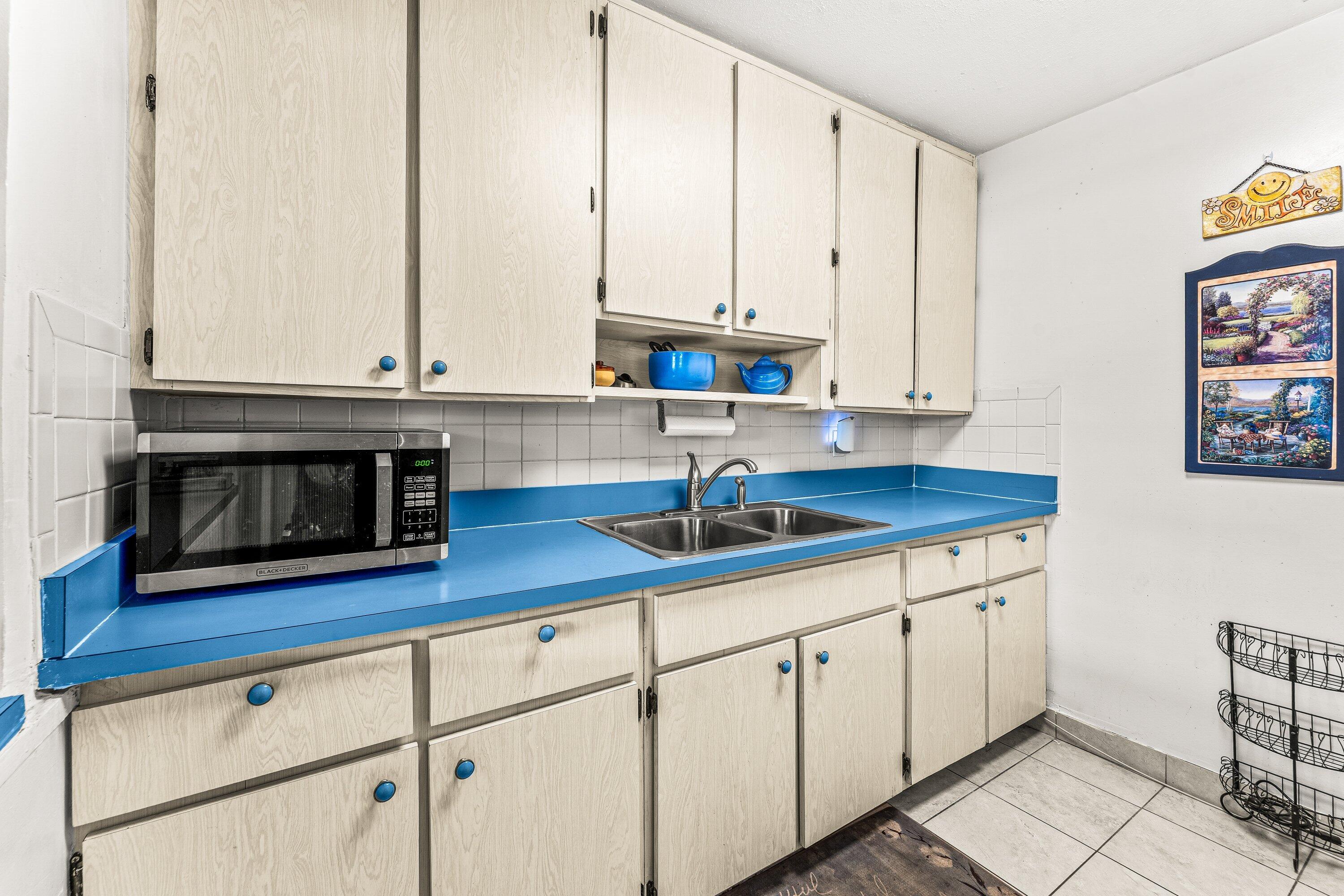 1040 West 1st Street Riviera Beach, FL 33404 - Photo 7 of 26 a kitchen with stainless steel appliances granite countertop a sink a stove and white cabinets