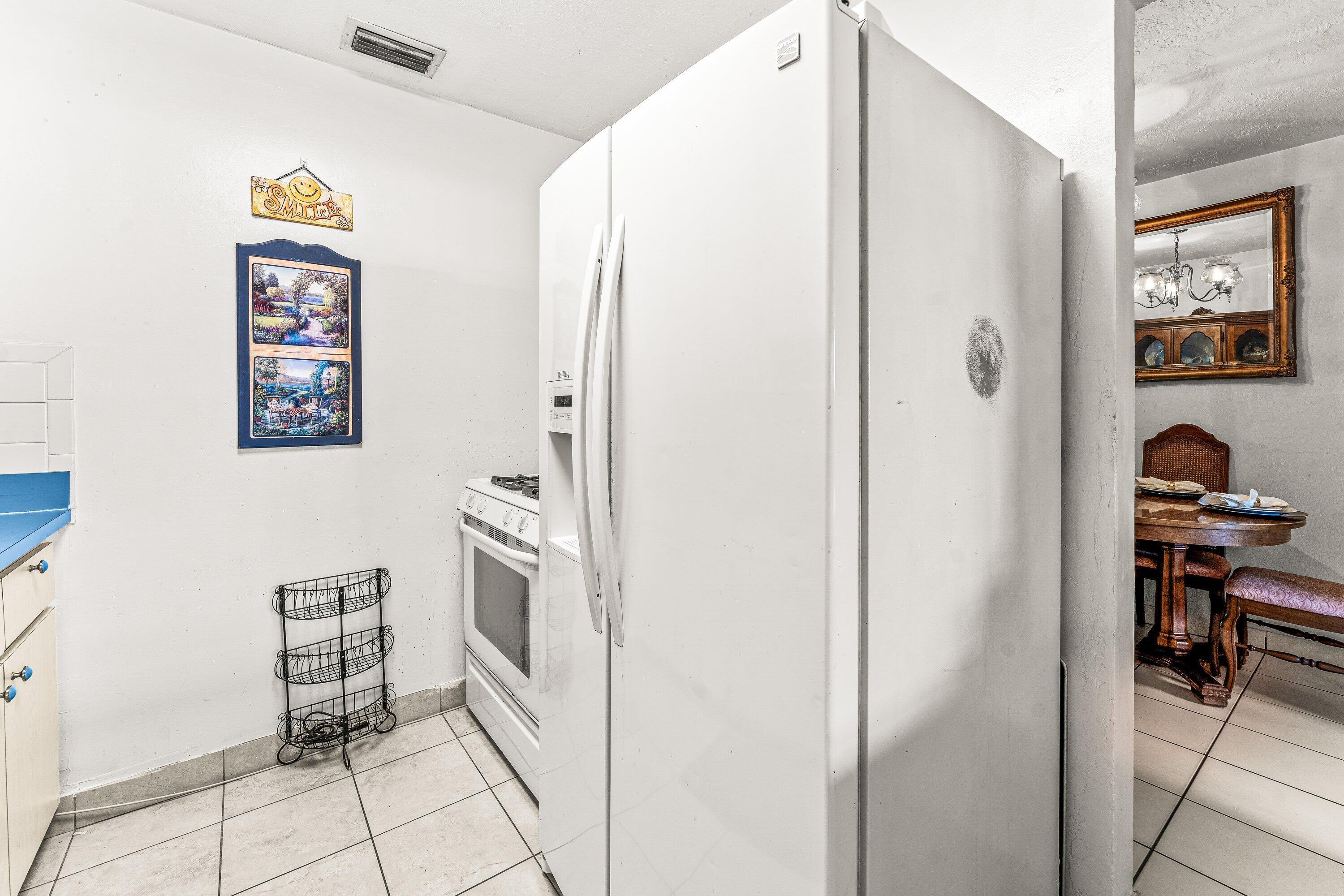 1040 West 1st Street Riviera Beach, FL 33404 - Photo 8 of 26 a kitchen with stainless steel appliances a refrigerator and a stove top oven