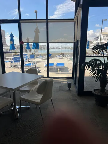 a dining room with furniture and a floor to ceiling window