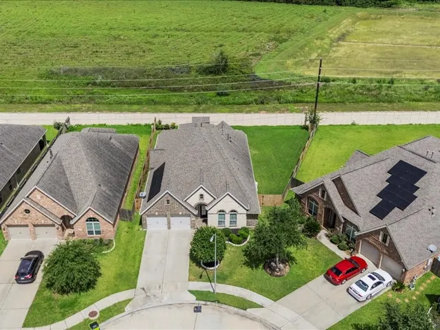 a large white kitchen with kitchen island a large counter top and stainless steel appliances